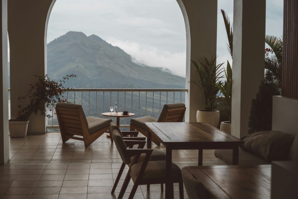 A seating area with chairs and a table overlooking a mountain.