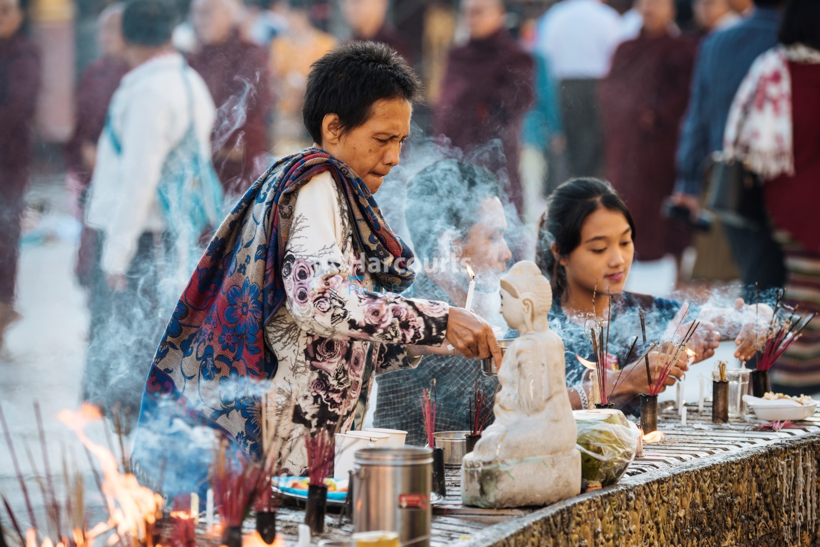 A moment of devotion with incense sticks at a temple ceremony.